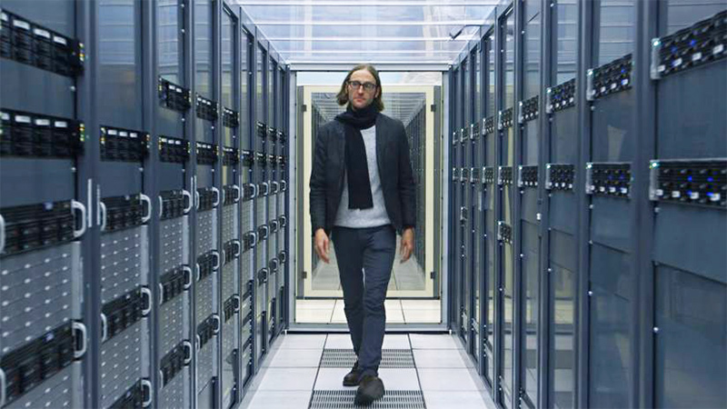 Dr. James Beacham, who is featured in 'Chasing Einstein,' walks past the servers at CERN, the largest particle physics laboratory in the world.