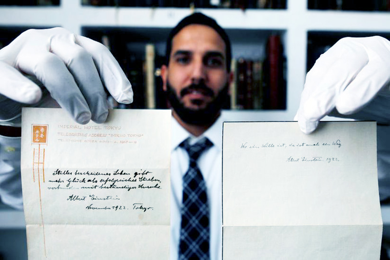 Gal Wiener, owner and manager of the Winner's auction house in Jerusalem, displays two notes written by Albert Einstein.
