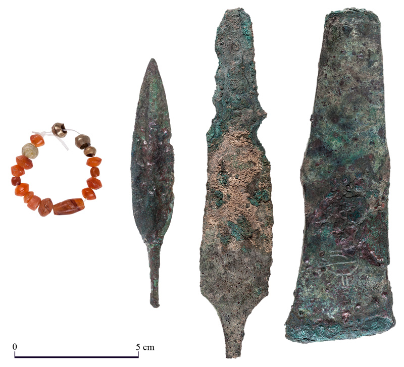 Jewelry and weapons found near the temple inner sanctum: beads, arrowhead, dagger, and axe head / T Rogovski