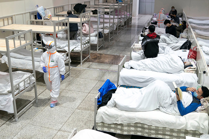 Medical workers in protective suits attend to patients at the Wuhan International Conference and Exhibition Center, which has been converted into a makeshift hospital to receive patients with mild symptoms caused by the novel coronavirus, in Wuhan, Hubei province, China February 5, 2020.