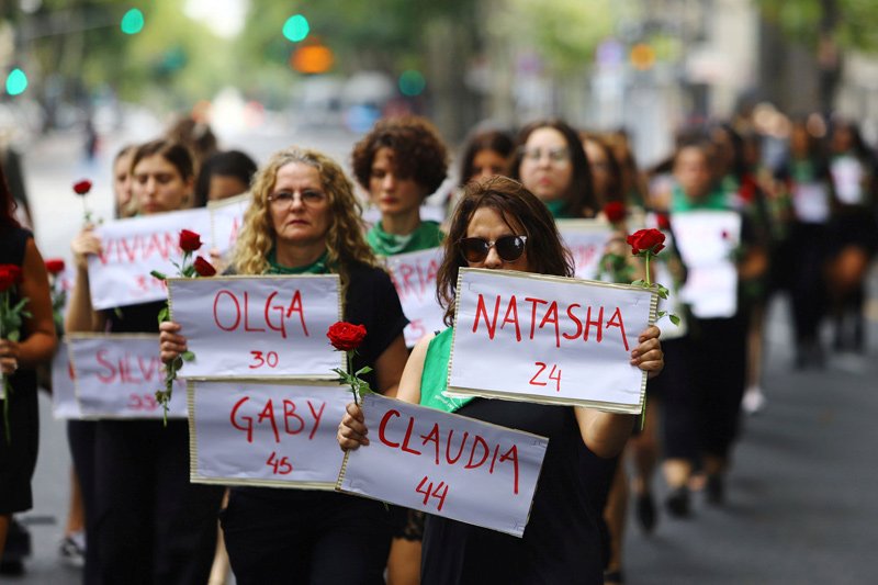 Women hold signs with the names of femicide victims at a protest marking International Women's Day in Buenos Aires, Argentina. March 8, 2020.