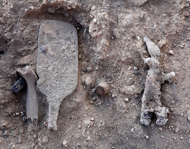 Lachish: close-up of the sceptre and a smiting god figurine in situ.