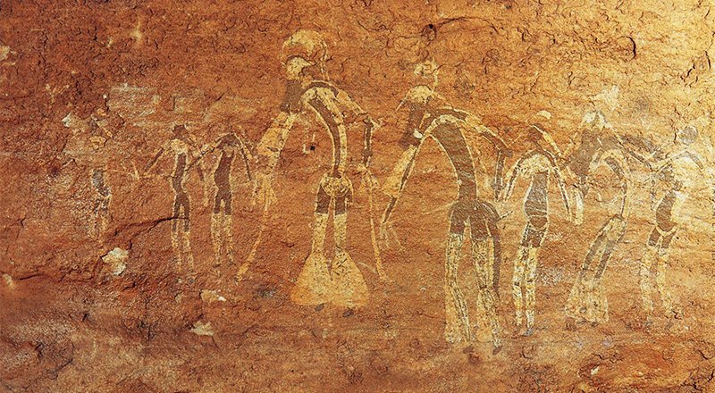 Neolithic rock paintings of dancing people at the Tassili n 'Ajjer National Park in Algeria.
