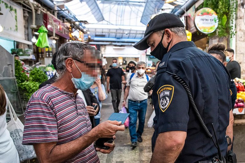 A police officer enforces mask regulations in Jerusalem's Mahane Yehuda market
