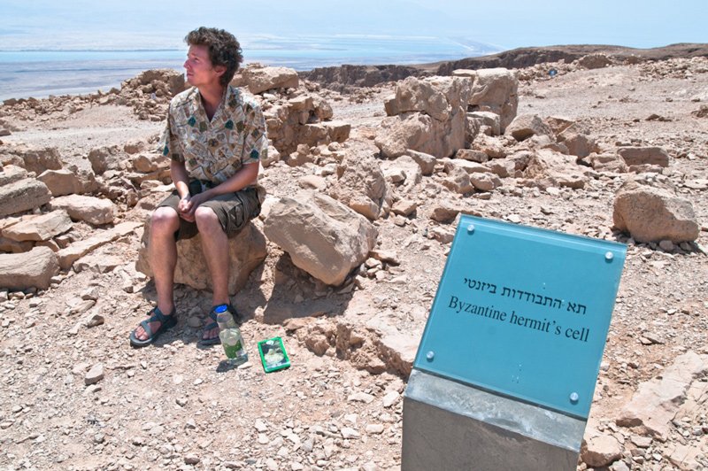 An archeology volunteer sitting near a Byzantine hermit’s cell at Tel Dor, 2011.