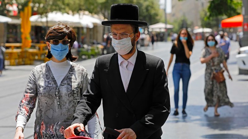 A Haredi couple wears masks as they walk in Jerusalem