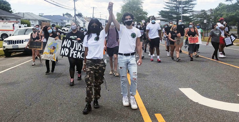 Madison Outing, 17, center left, and Michael Haggerty, 17, center right, at a protest they organized in Farmingdale, N.Y. Teenagers are also using TikTok to express their social and political beliefs.