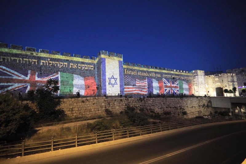 The flags of countries that are home to Jewish communities hard hit by COVID-19 projected on to the walls of the Old City of Jerusalem in a show of support sponsored by the Diaspora Affairs Ministry on May 12, 2020.