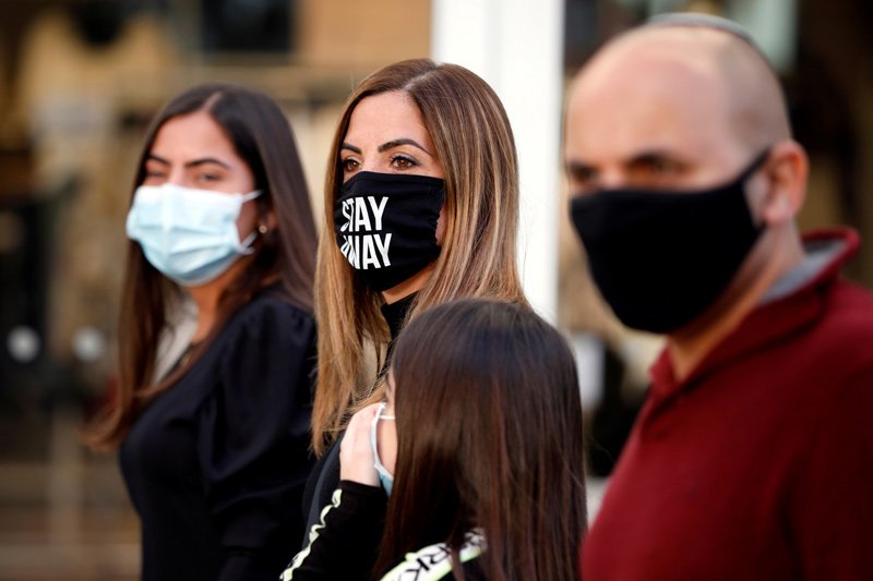 Shoppers wear face masks and walk around a fashion shopping center in Ashdod, as restrictions over the coronavirus disease (COVID-19) ease around Israel, May 5, 2020.
