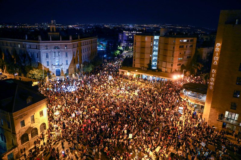 Thousands of protesters chant slogans and hold signs during a protest against Israel's Prime Minister Benjamin Netanyahu outside his official residence in Jerusalem, Saturday, Aug 1, 2020.