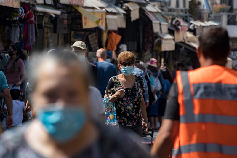 Israelis, wearing face masks to protect from the coronavirus, shop at the Mahane Yehuda market in Jerusalem on July 21, 2020.
