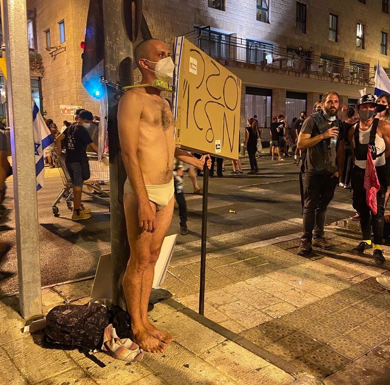 A man tying himself to a pole in protest of a coronavirus lockdown, in Jerusalem on September 12, 2020.