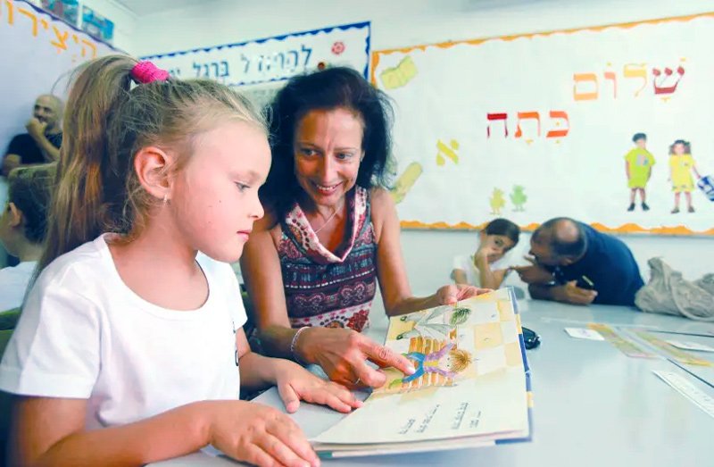Parents and pupils read together in a first grade class at Paula Ben-Gurion School in Jerusalem.