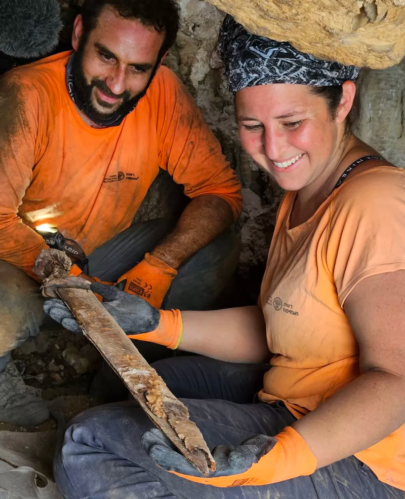 Archaeologists Hagay Hamer and Oriya Amichay with one of the swords found in the cave